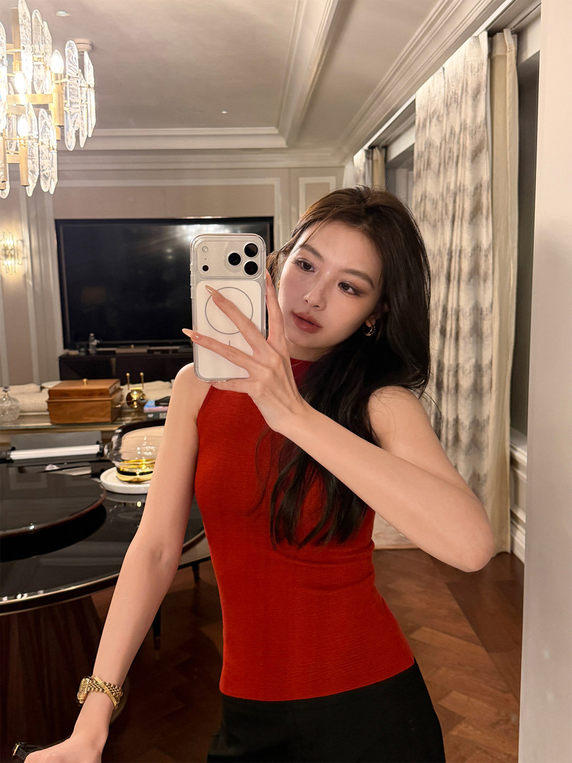 Woman wearing a fitted red sleeveless top in a mirror selfie