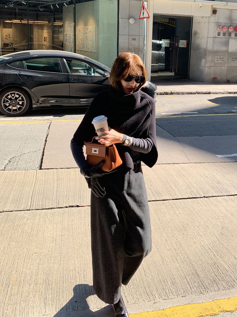 Woman wearing a black minimalist layered outfit while walking outdoors