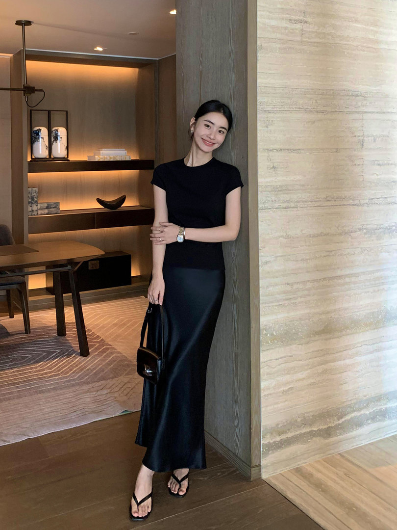 Woman wearing a black short-sleeve maxi dress with black sandals