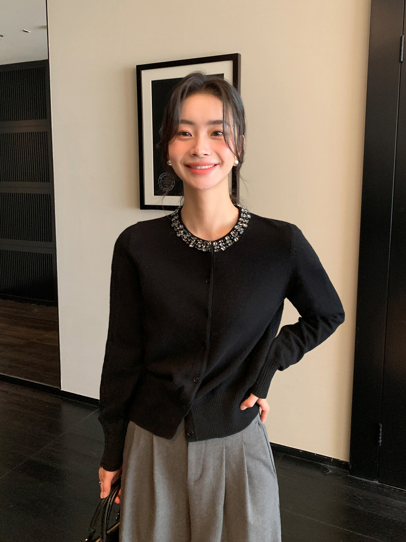 Black long-sleeve cardigan with a jeweled collar worn by a model