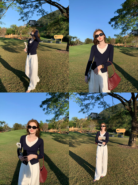 Woman wearing a navy cardigan with cream wide-leg pants outdoors