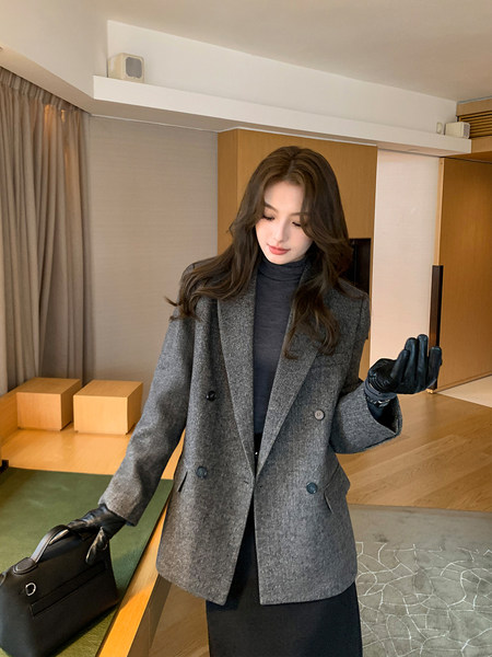 Woman wearing a gray double-breasted blazer with turtleneck and gloves