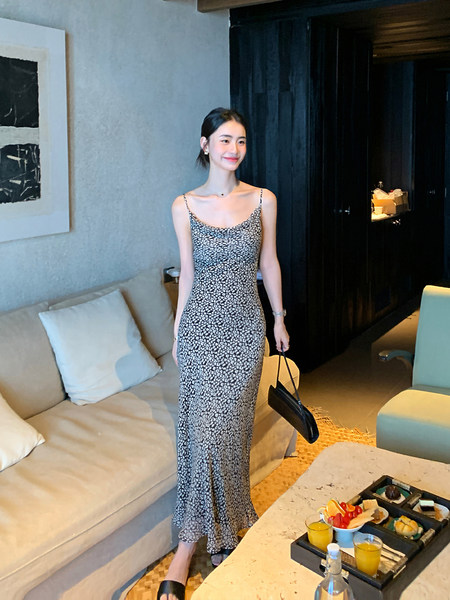 Woman wearing a black-and-white floral spaghetti strap slip dress