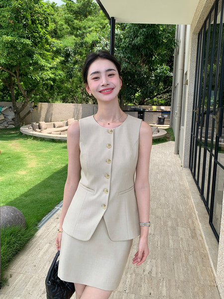 Woman wearing a beige sleeveless blazer-style dress set outdoors