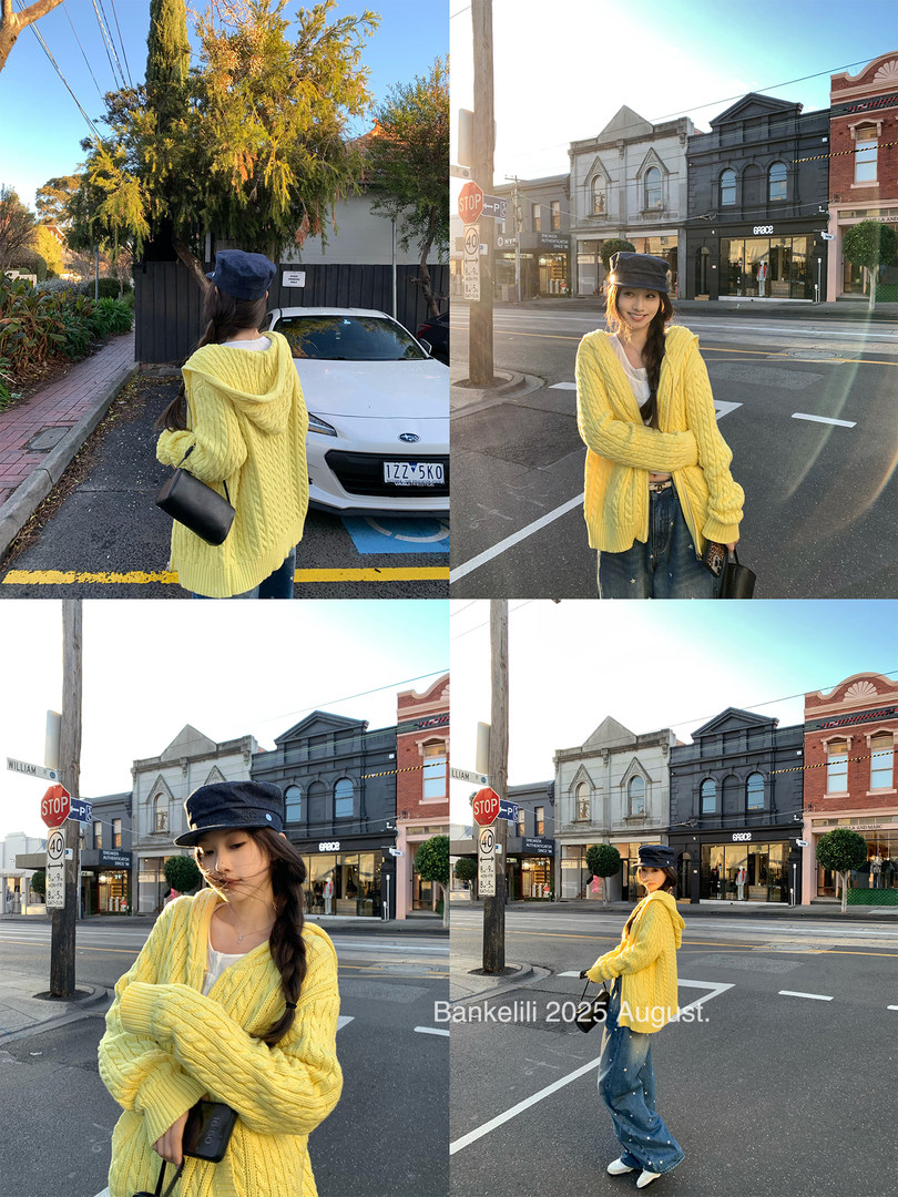 Woman modeling a yellow cable-knit cardigan on a city street