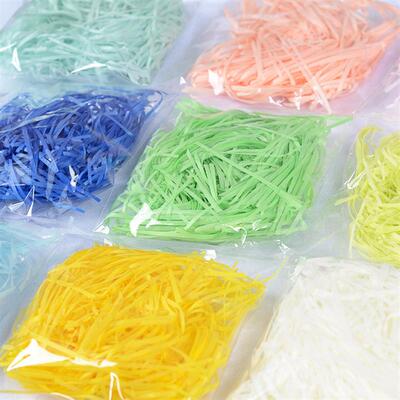 gift lined with shredded paper filling colored packing box