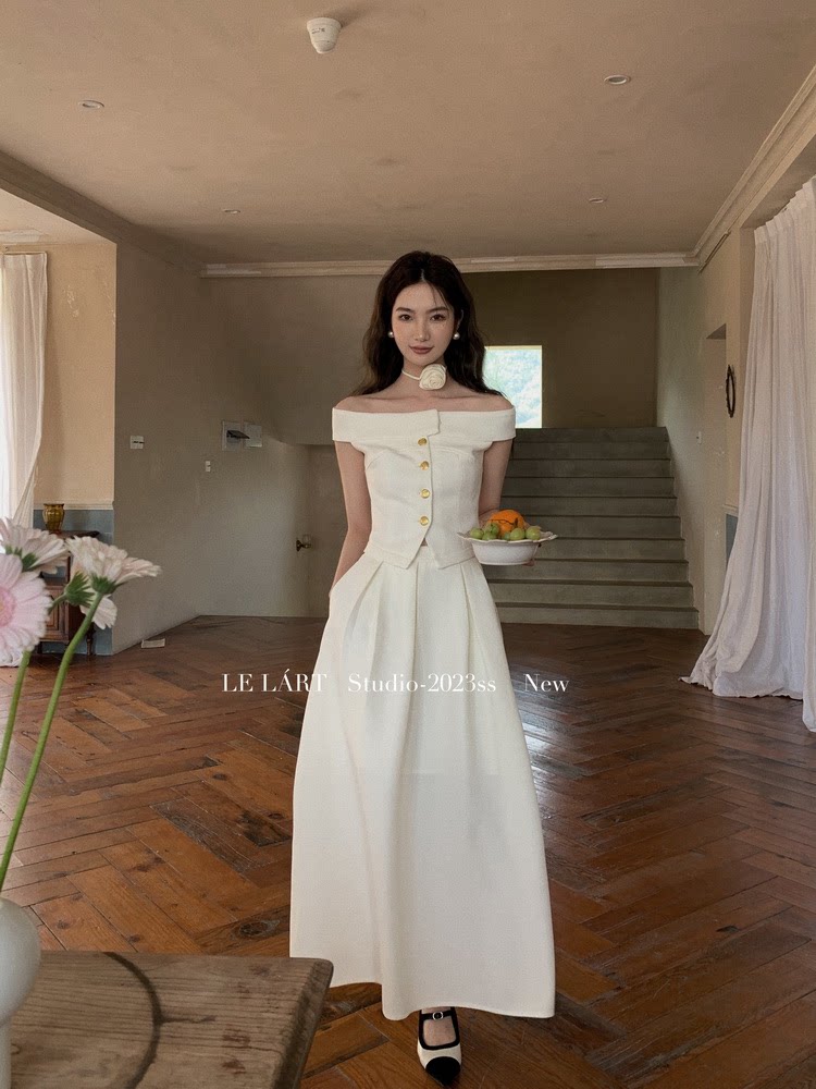 Woman wearing a white off-shoulder button-front maxi dress
