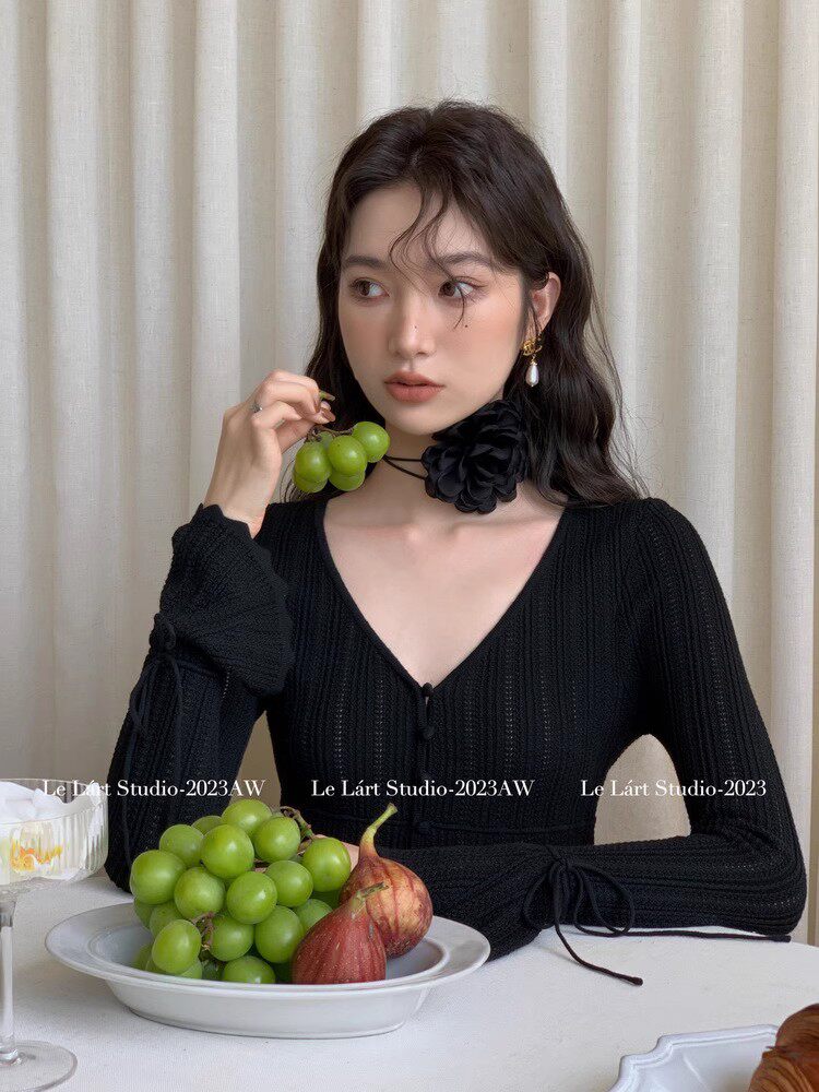 Black long-sleeve V-neck knit dress worn by a woman
