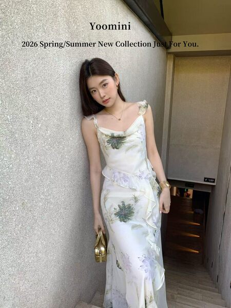 Model wearing a white floral slip dress with ruffled details