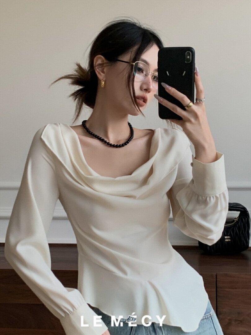 White long-sleeve draped blouse worn by a model in a mirror selfie