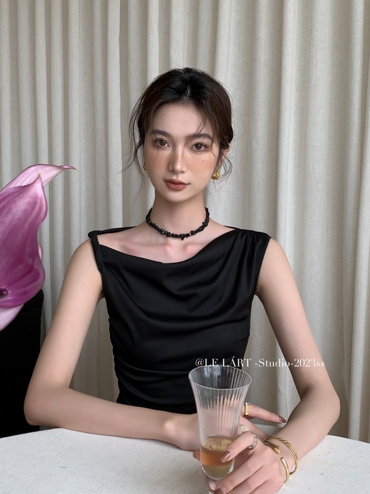 Black sleeveless draped dress worn by a model