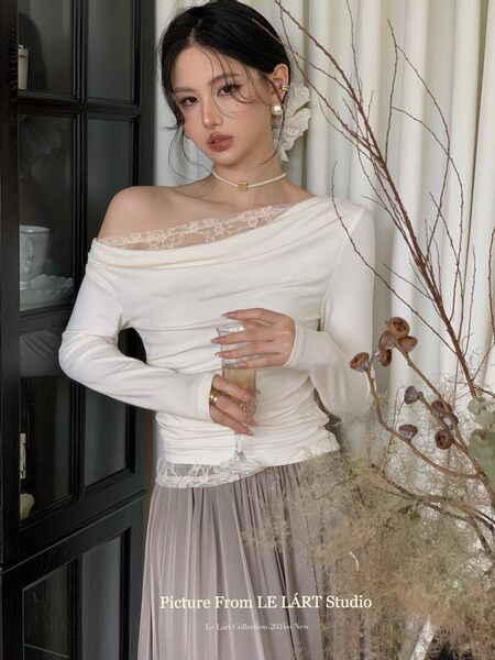 Woman wearing a white off-shoulder lace-trim top with a flowing skirt