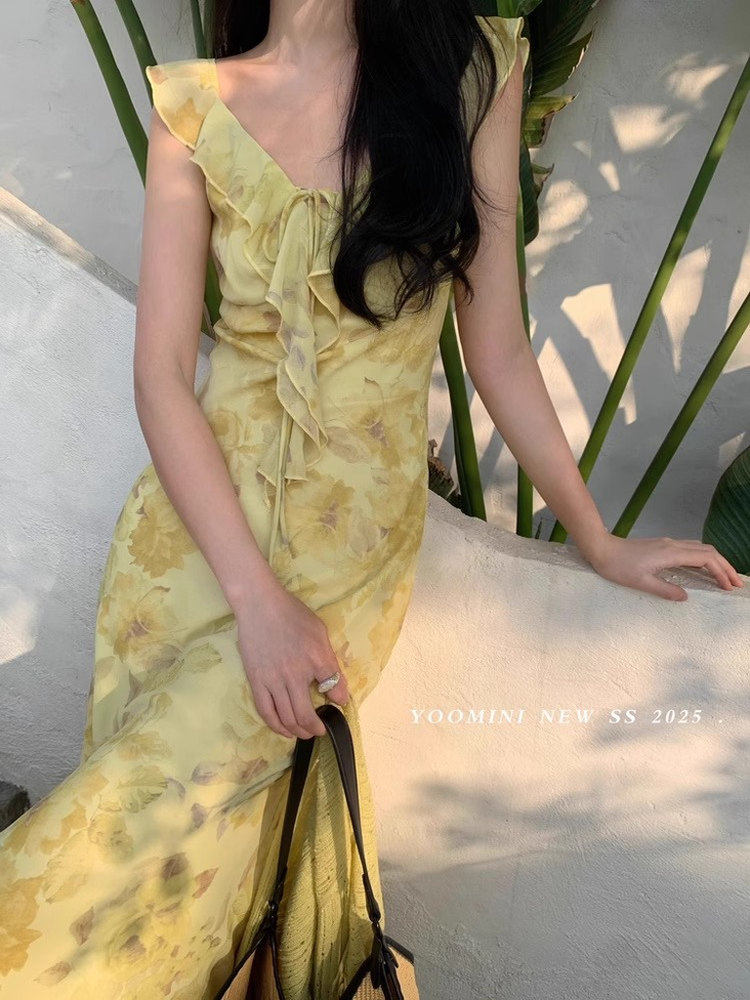 Yellow floral ruffled dress worn by a model outdoors