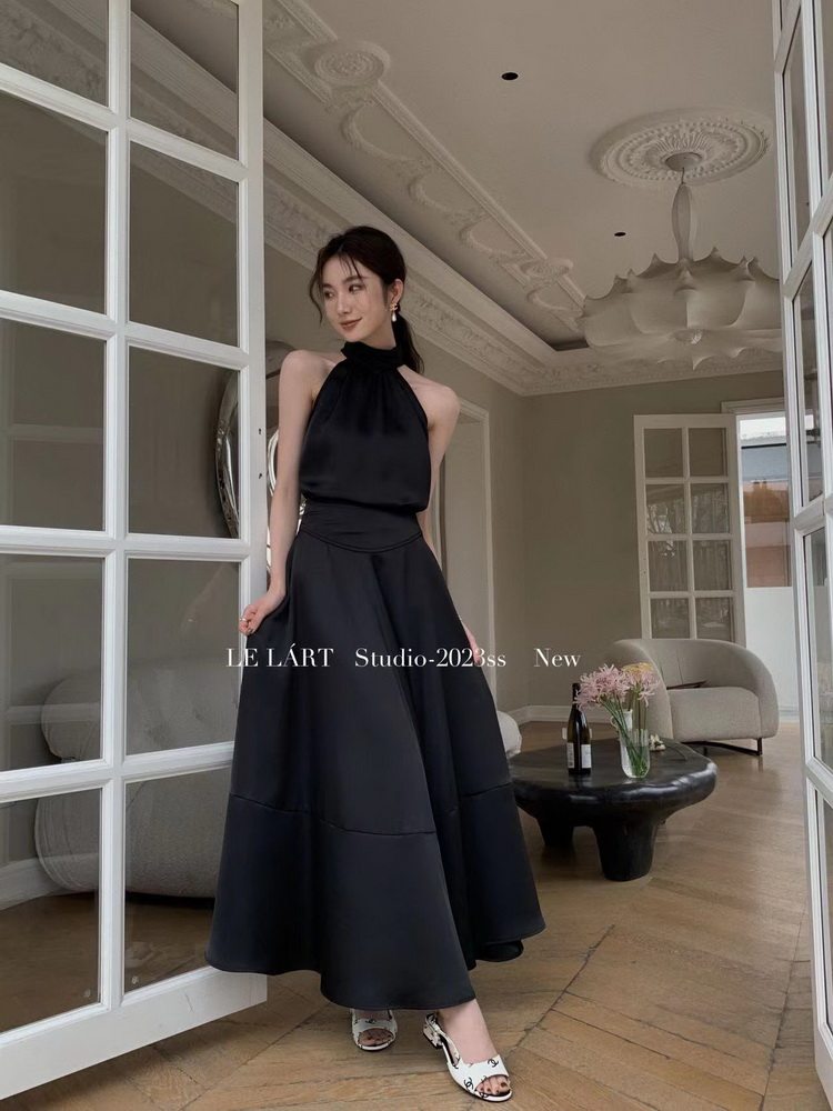 Black halter-neck maxi dress worn by a model indoors