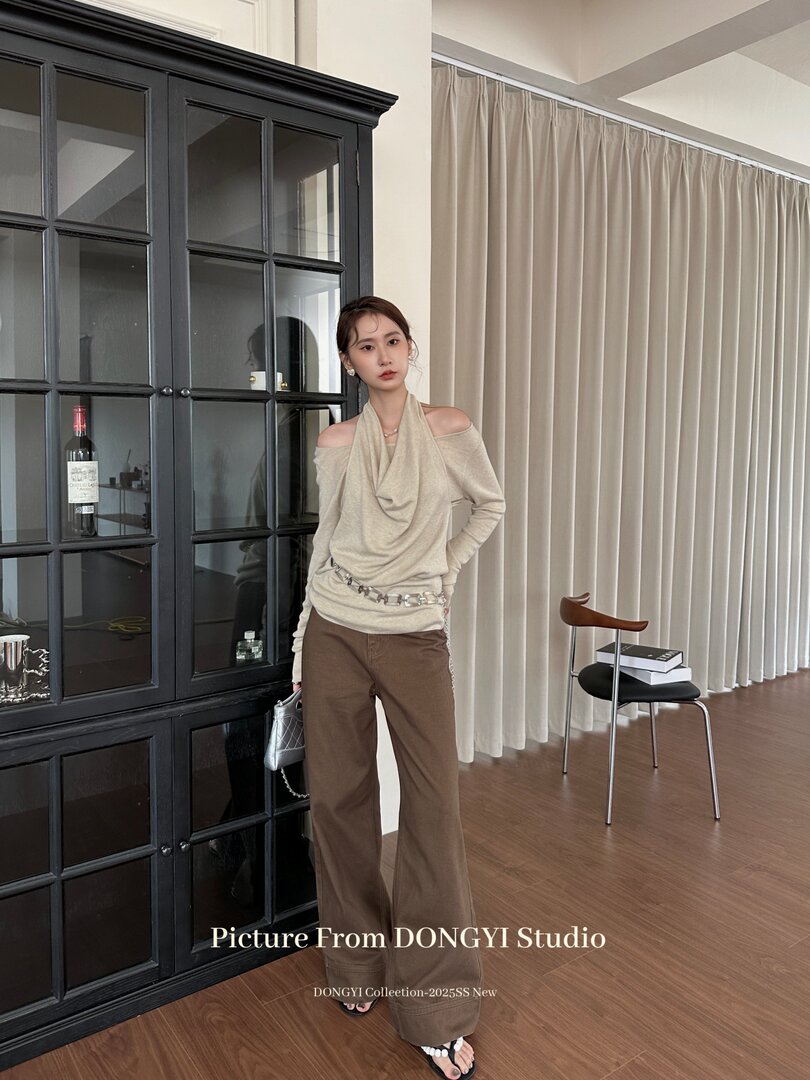 Model wearing a beige off-shoulder knit top with brown wide-leg pants