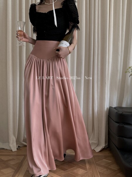 Woman modeling a flowing pink wide-leg skirt or maxi skirt with a black crop top