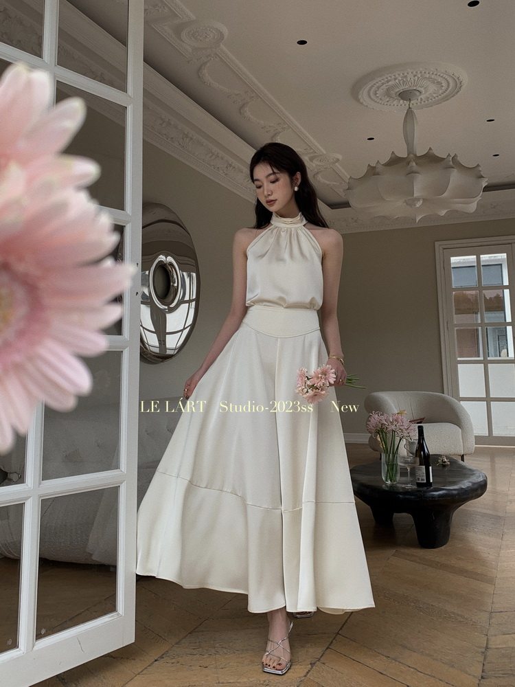 Woman wearing a cream halter-neck maxi dress indoors