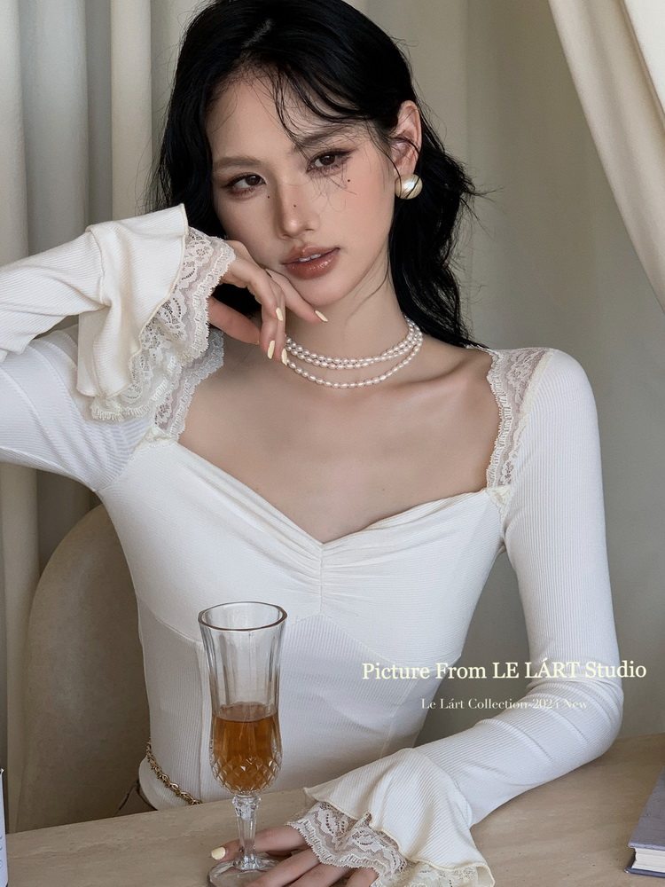 White long-sleeve lace-trim fitted top worn by a model