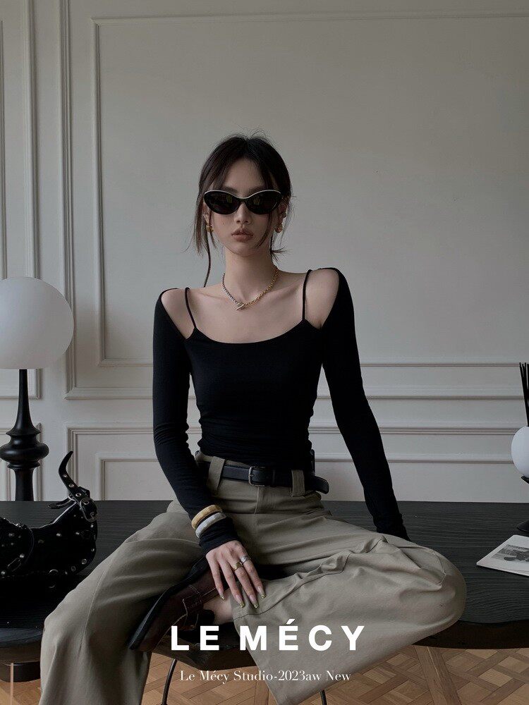 Model wearing a black off-shoulder fitted top with wide-leg trousers