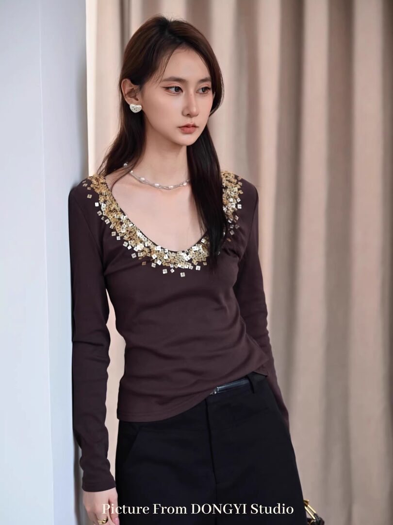 Woman wearing a dark brown embellished long-sleeve top