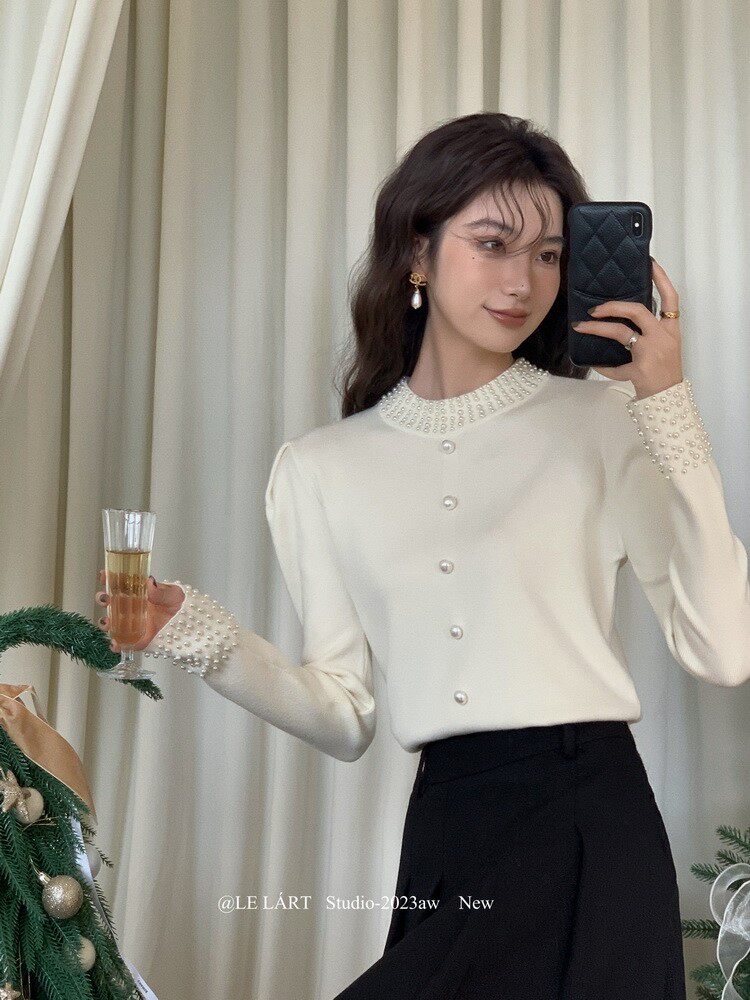 Woman wearing an ivory embellished long-sleeve cardigan top
