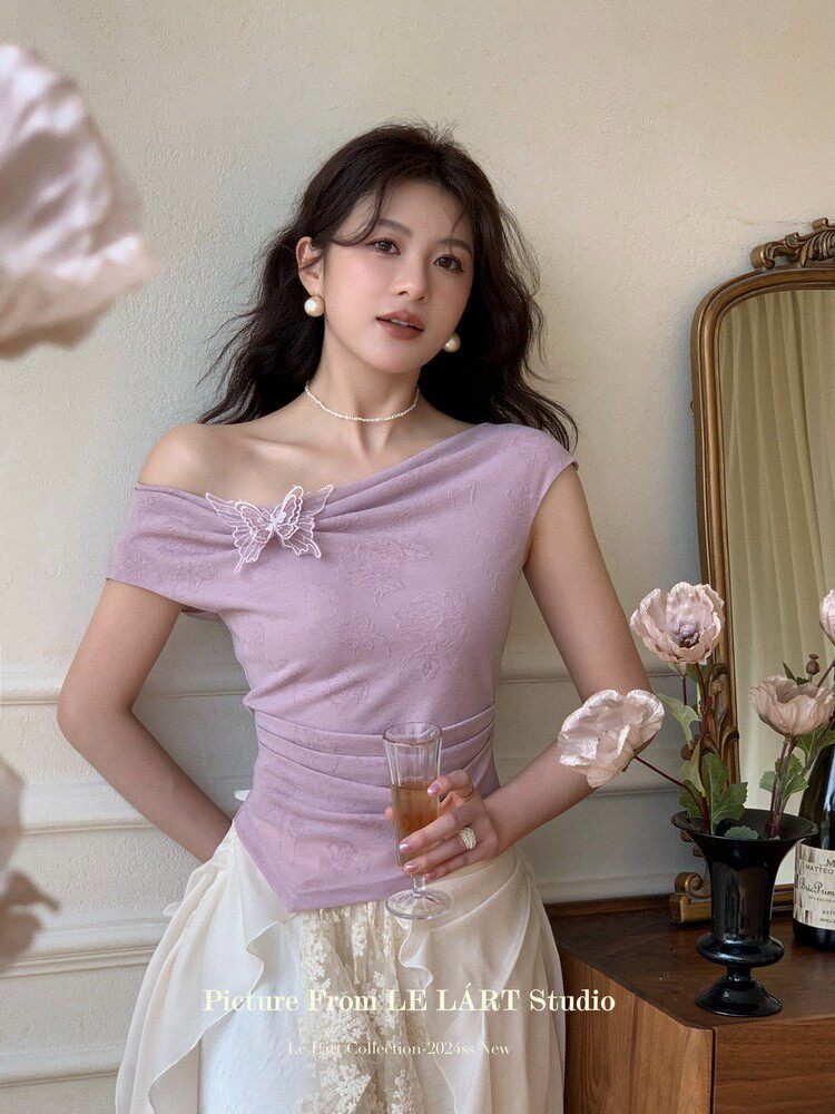 Woman wearing a lavender off-shoulder fashion top with floral detail