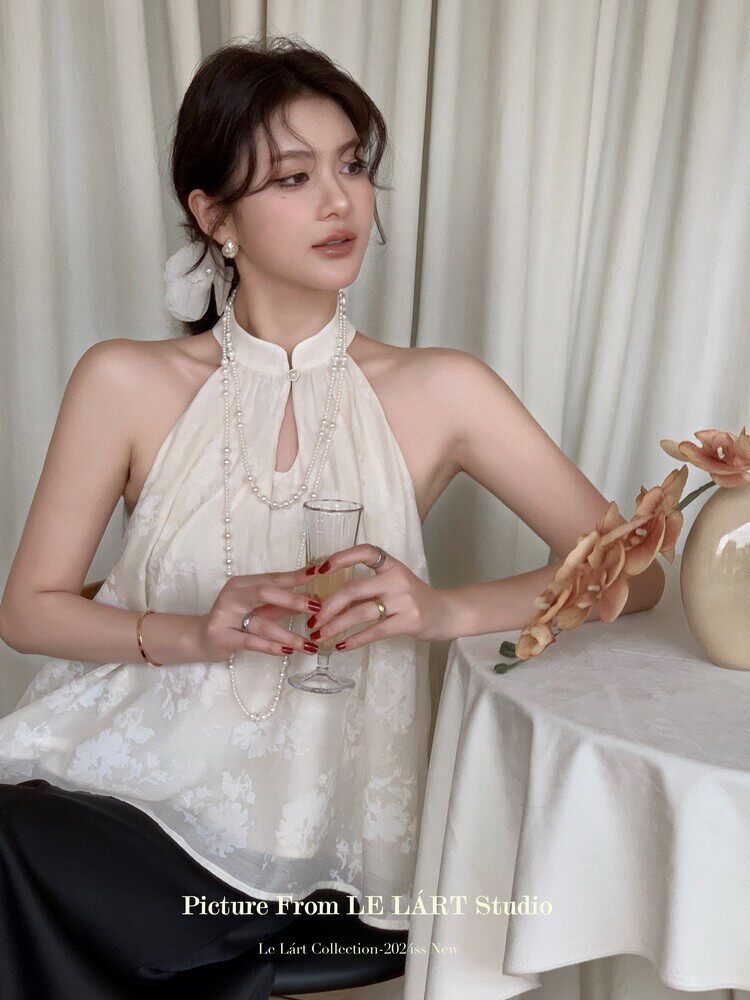 Woman wearing a white halter dress with pearl necklace