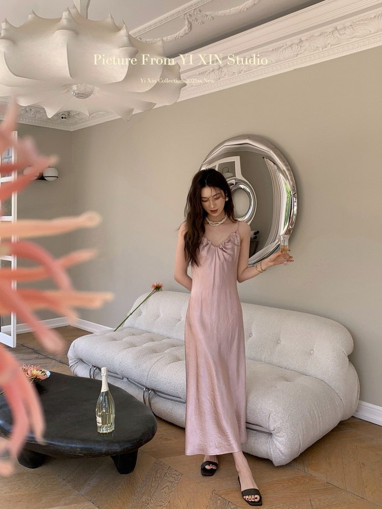 Woman wearing a pink satin slip dress in a living room