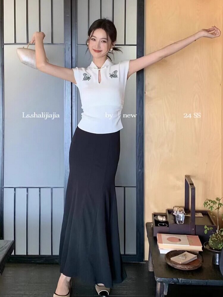 Woman wearing a white sleeveless top with a black maxi skirt
