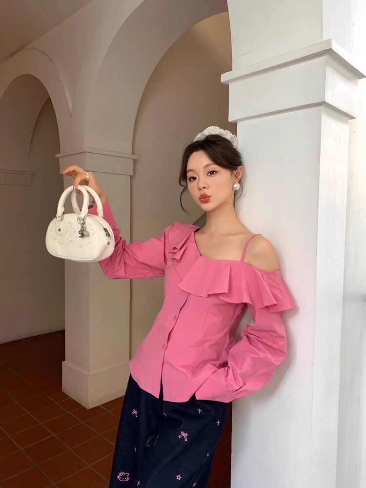 Model wearing a pink off-shoulder ruffled blouse and holding a small white handbag