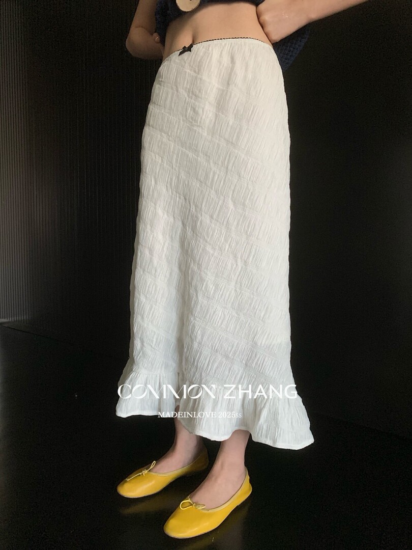 White textured maxi skirt worn by a model with yellow flats
