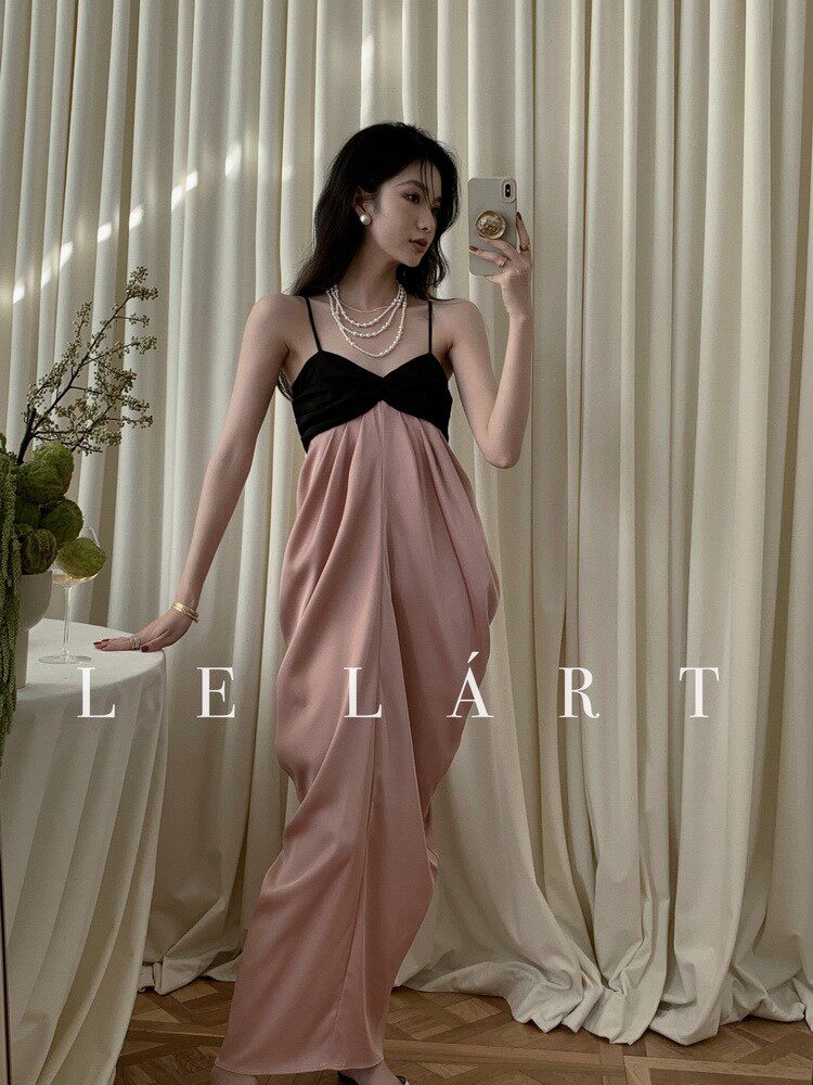 Model wearing a pink and black sleeveless dress in a mirror selfie