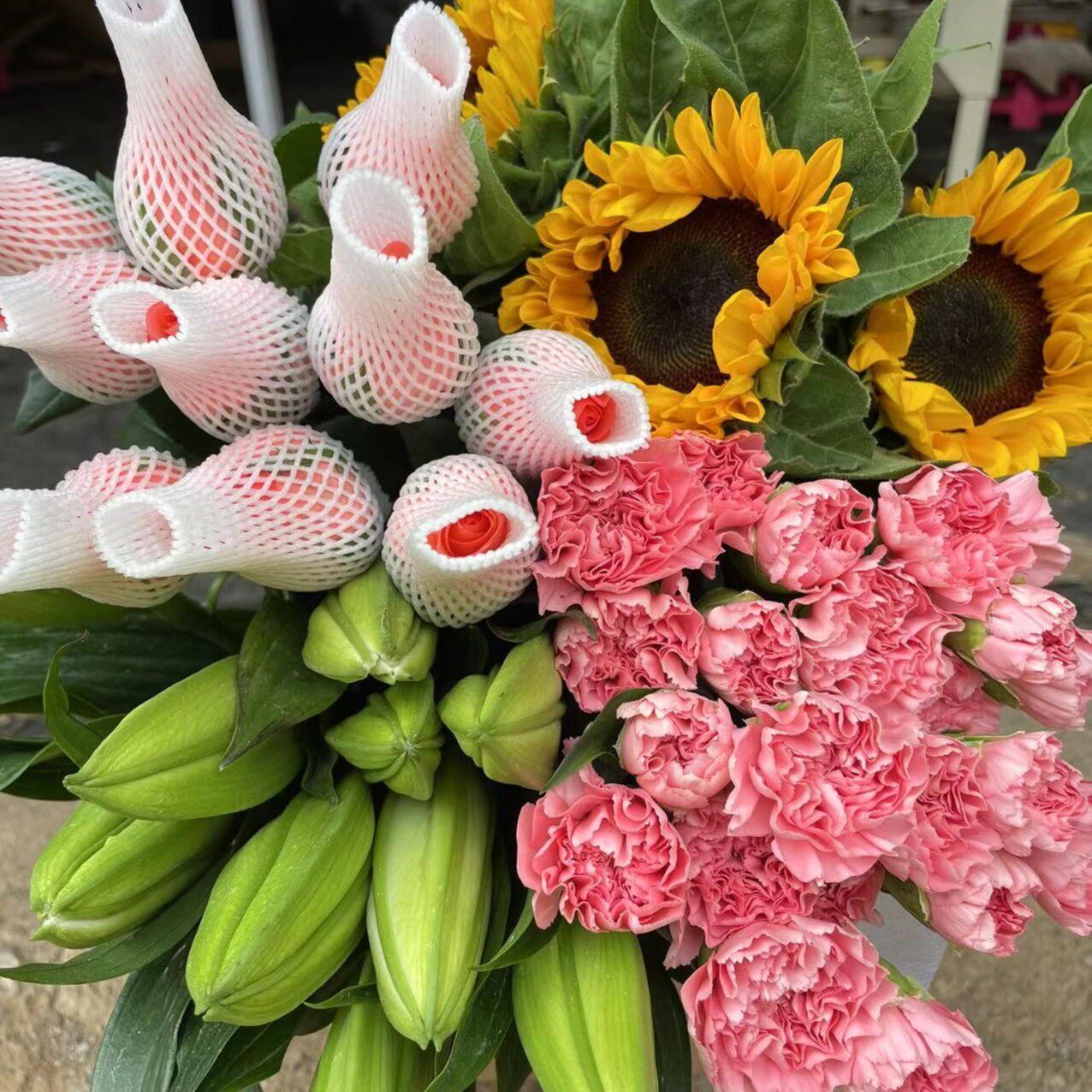 粉玫瑰10枝+香水百合5朵+混色康乃馨10枝+向日葵2枝+配草1扎
