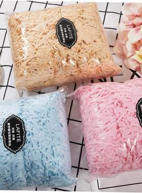 gift lined with shredded paper filling, colored packing box