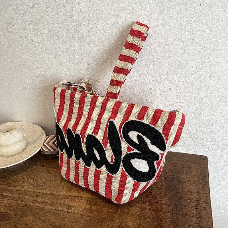 夏季手提条纹水桶包斜挎包包女百搭宽超火小众帆布包肩带2026新款