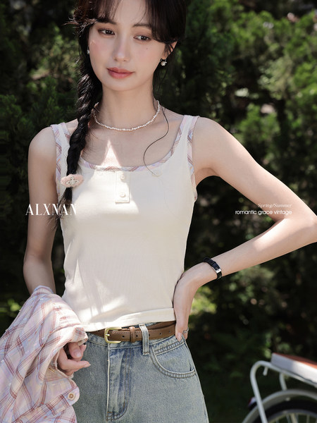 Model wearing a light sleeveless ribbed tank top with a plaid shirt draped over her arm