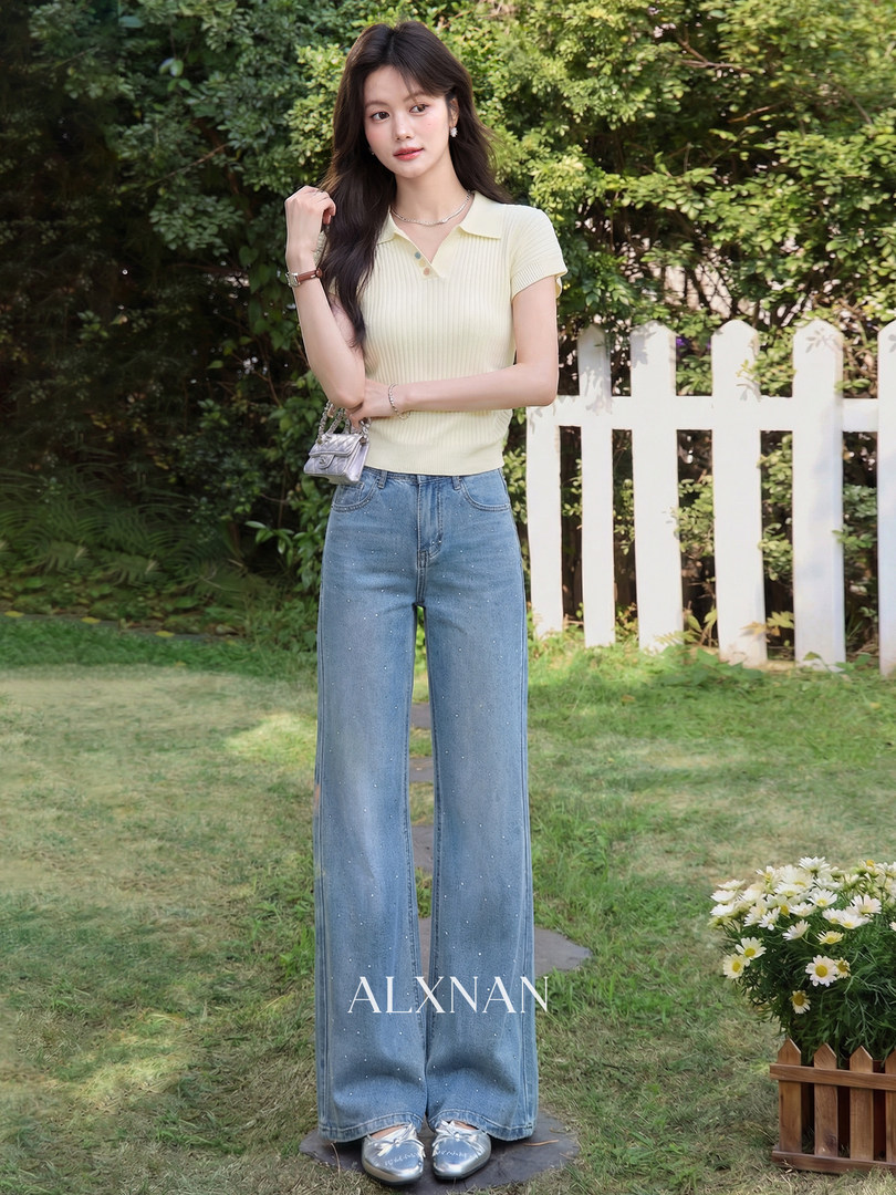 Model wearing a pale yellow knit polo top with wide-leg blue jeans outdoors