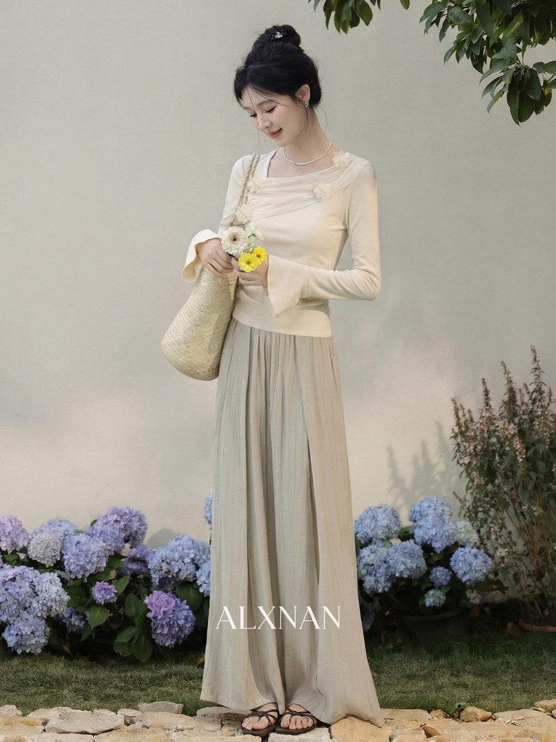 Model wearing a cream long-sleeve top and wide-leg pleated pants set