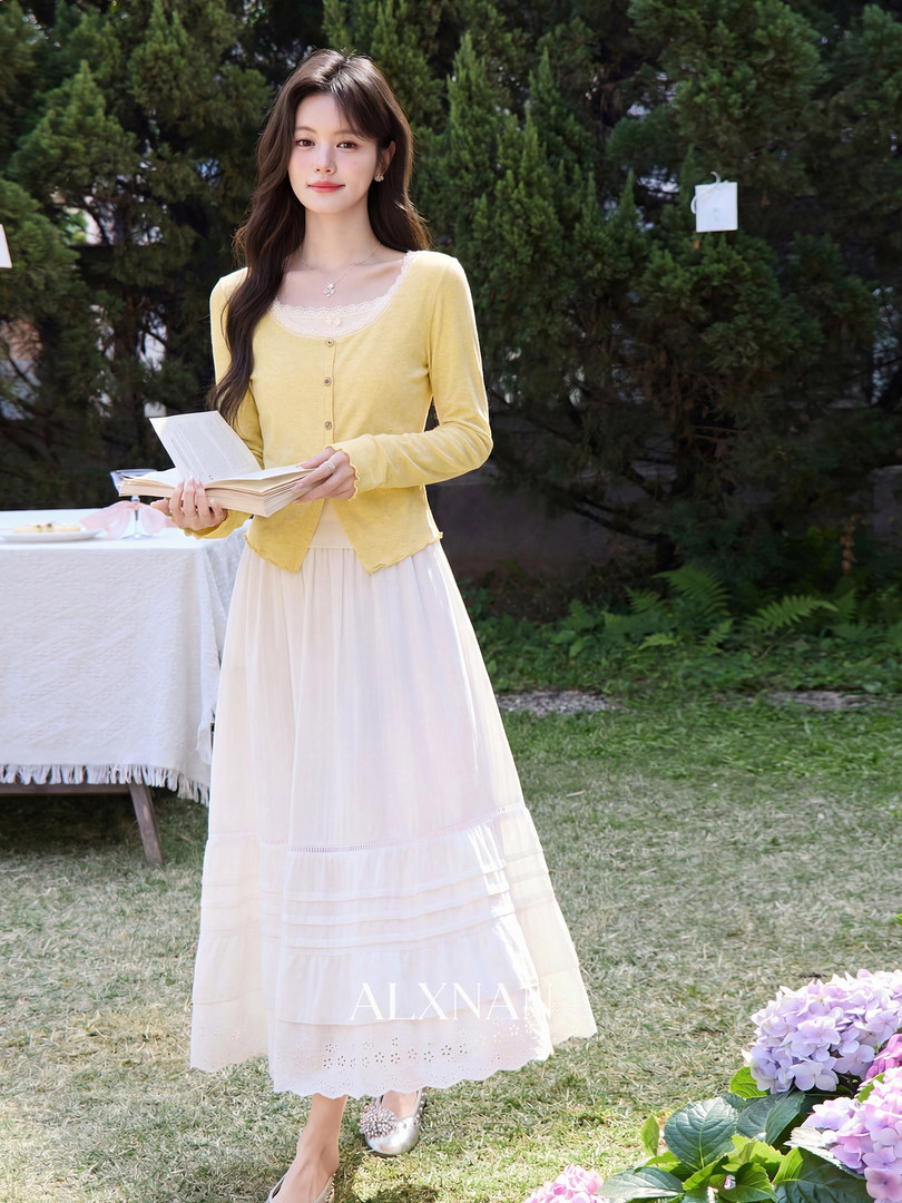 Woman modeling a yellow cardigan with a white midi skirt outdoors