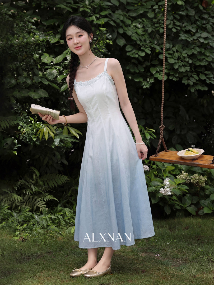 Woman wearing a sleeveless white-to-blue gradient dress outdoors
