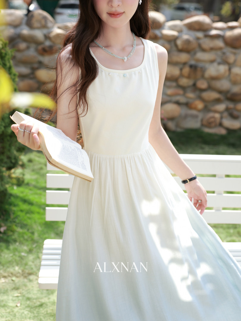 Woman wearing a white sleeveless maxi dress outdoors