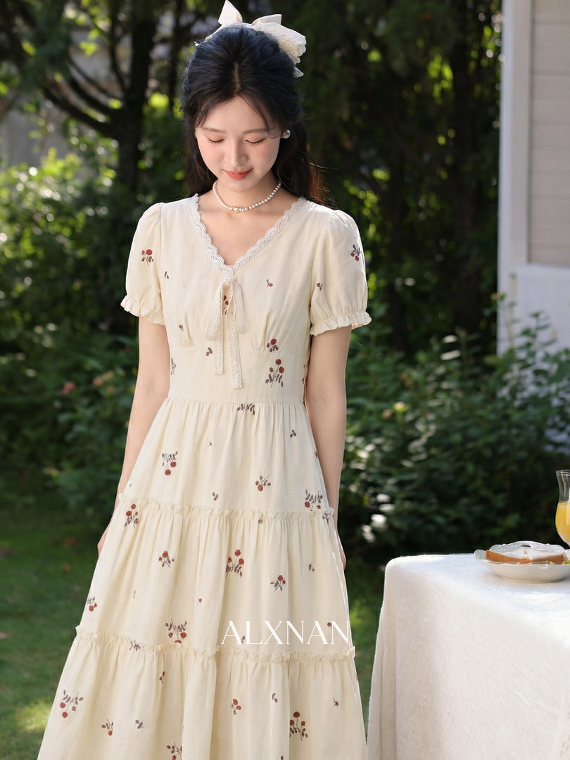 Cream floral tiered dress worn by a model outdoors