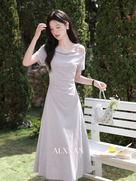 Light gray off-shoulder maxi dress worn by a model outdoors