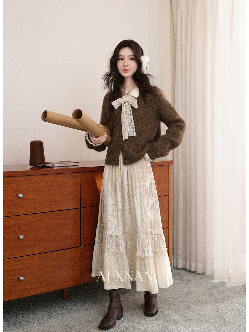 Model wearing a brown fuzzy cardigan with a cream lace maxi skirt and boots