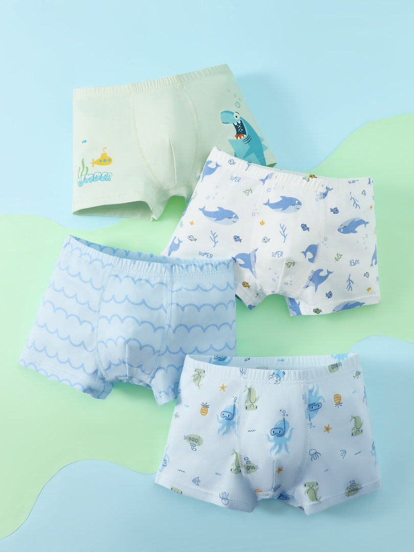 Four pairs of boys' patterned boxer briefs laid flat with ocean-themed prints