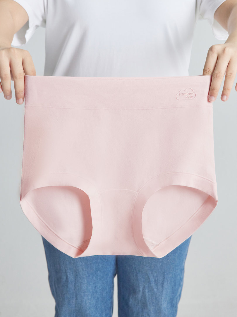Pink high-waisted underwear briefs held up by a person