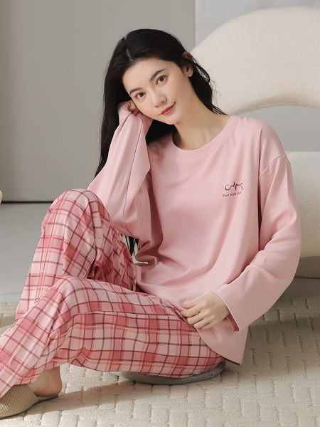 Model wearing a pink long-sleeve loungewear set with plaid pants
