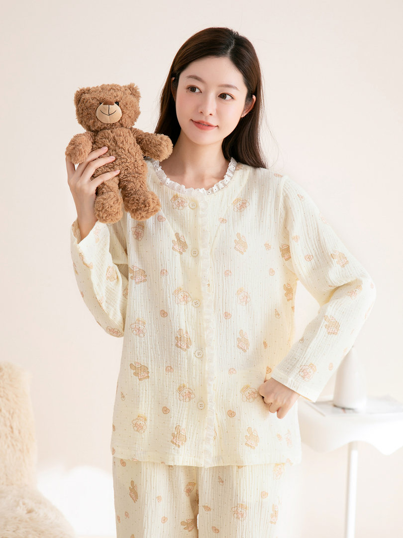 Woman wearing cream printed loungewear pajamas while holding a teddy bear
