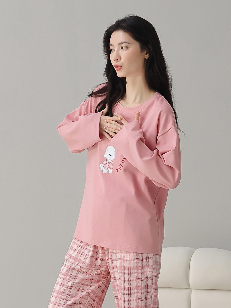 Woman wearing a pink pajama-style loungewear set with plaid pants