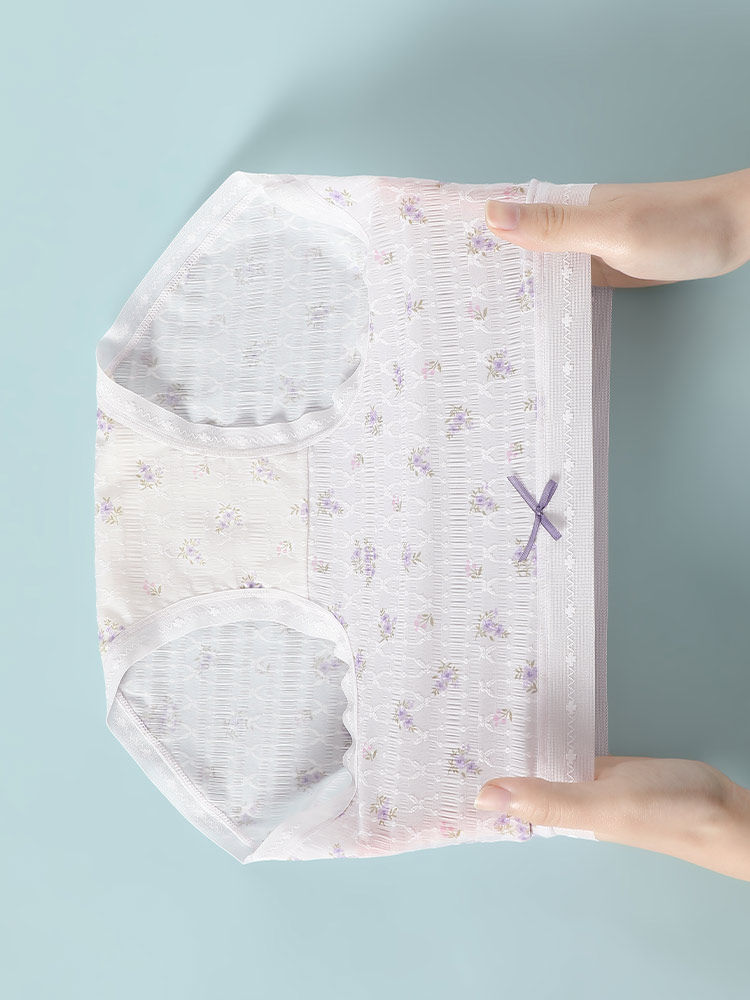 Light pink floral underwear briefs held by hands